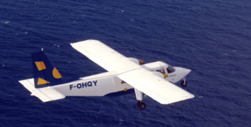 Location jet privé : BN2 Islander survolant océan bleu.