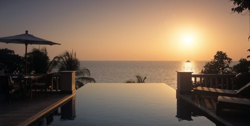 Piscine à débordement : coucher de soleil tropical océan et patio.