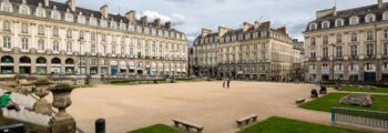 location de jet privé : Cathédrale gothique, arbres et ciel nuageux.