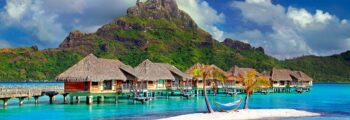 Vue panoramique sur la plage avec des eaux turquoise et des collines.