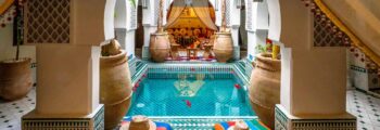 Hôtel Burj Al Arab ; canal et palmiers en arrière-plan.